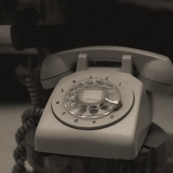Klasický biely telefón symbolizujúci nepretržitú dostupnosť. Pohrebná telefonická pohotovosť Javorium dostupná 24 hodín denne, 7 dní v týždni.