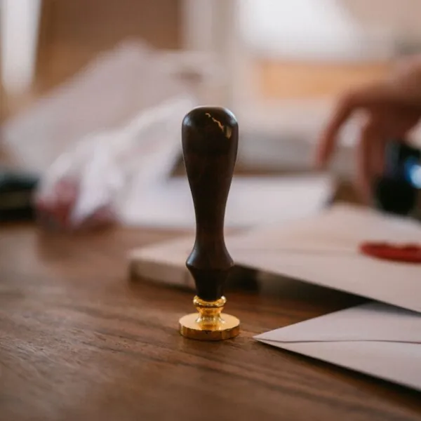 Drevená úradná pečať na stole s dokumentmi. Zastupovanie pozostalých na matrike a iných úradoch pri vybavovaní úmrtnej dokumentácie.